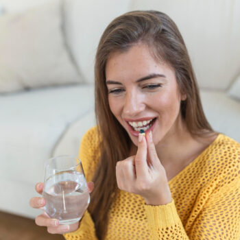 Imagem mulher sorridente tomando pilula